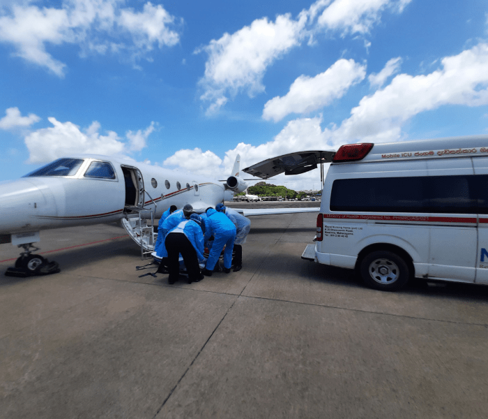 A patient being boarded on to a private jet next an ambulance.